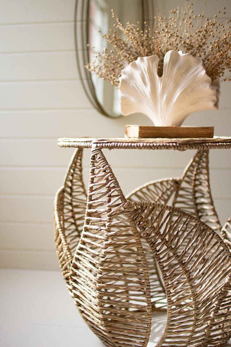 Woven seagrass side table with fern leaf detail styled in a coastal room