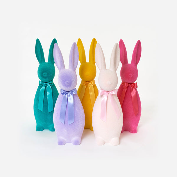Five colorful bunny-shaped bottles with ribbons on a white background