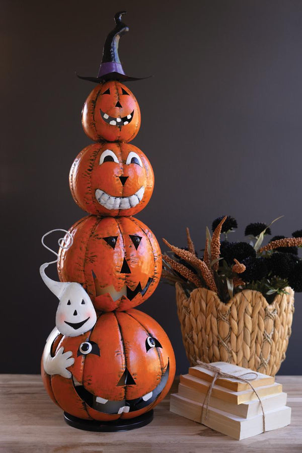 Four stacked painted jack-o-lanterns topped with a witch hat