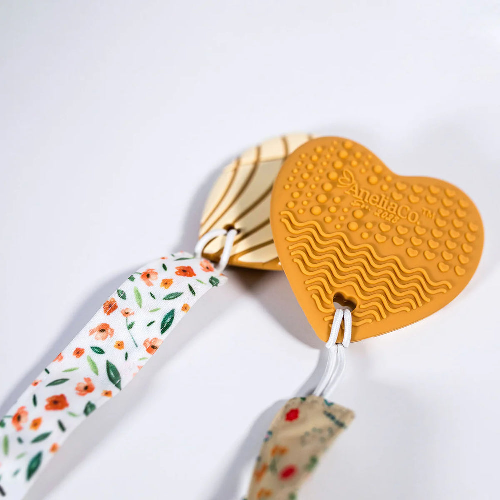 Heart-shaped keychain with floral ribbon on a white background