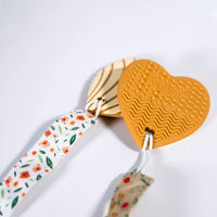 Heart-shaped keychain with floral ribbon on a white background