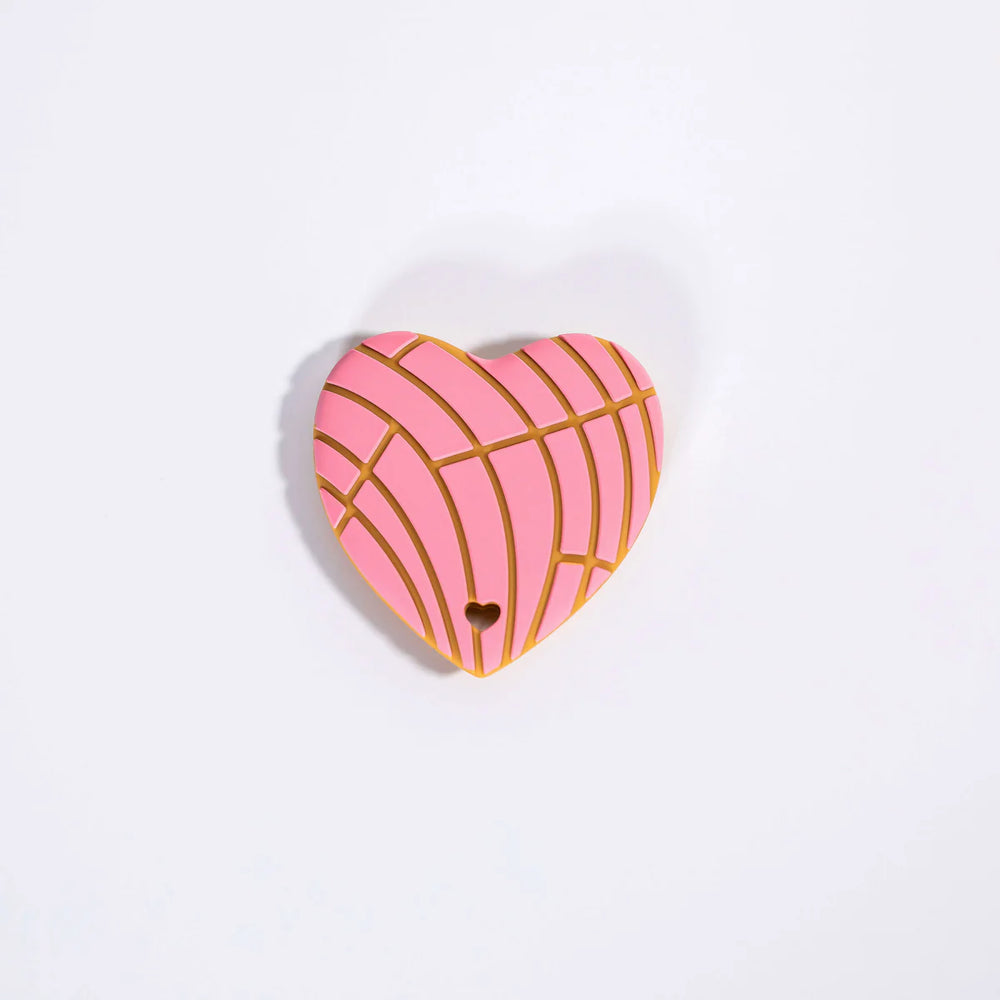 Heart-shaped pink and gold decorative item on a white background