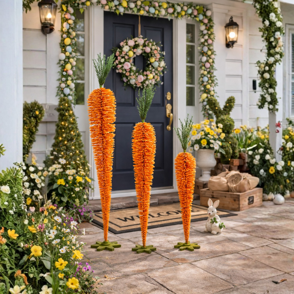 Decorative carrots and floral arrangements on a front porch with a wreath on the door.