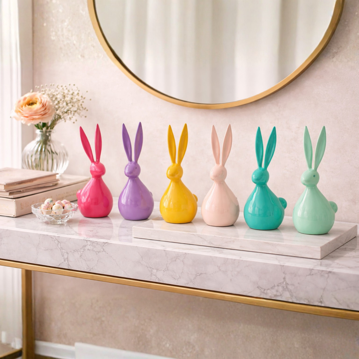 Colorful rabbit-shaped decorative items on a marble surface with a mirror in the background.