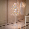 Decorative tree with colorful eggs in a room with marble flooring and a chandelier.
