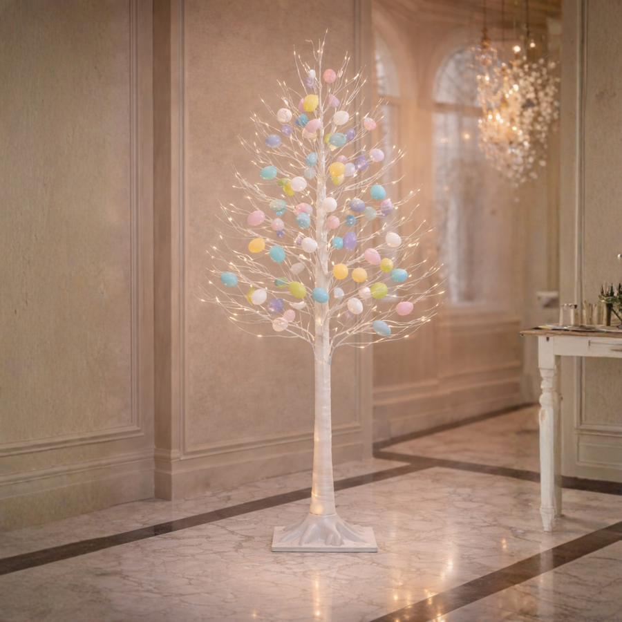 Decorative tree with colorful eggs in a room with marble flooring and a chandelier.