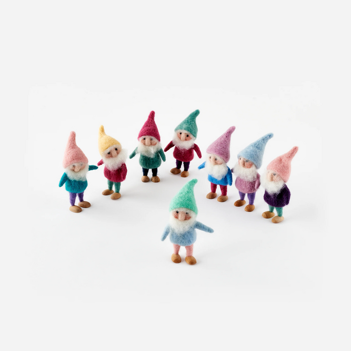 Small figurines of gnomes in colorful outfits on a white background