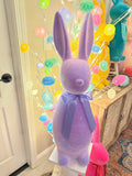Purple plush toy with colorful beads on a wooden surface