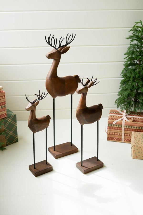 Set of three carved wood reindeer with iron legs and antlers on bases