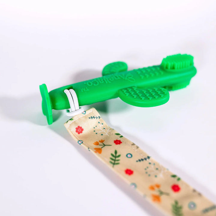 Green dog toy with floral-patterned fabric on a white background