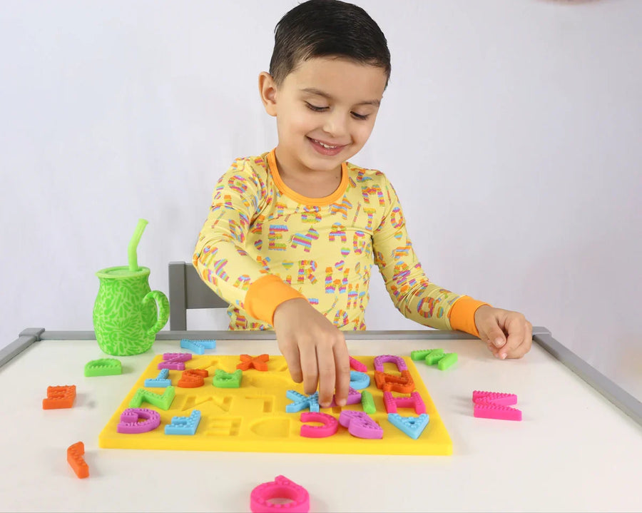 A toddler playing with the Spanish alphabet puzzle