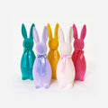 Five colorful bunny-shaped bottles with ribbons on a white background