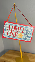 Admit One vintage carnival ticket ornament with red scalloped border, mint stripes and gold star, displayed on a gold stand