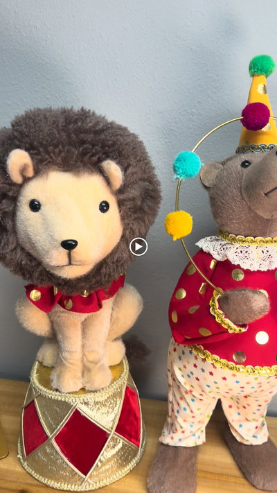 Circus Christmas decor: lion on gold and red drum pedestal and juggling bear holding a pom-pom hoop