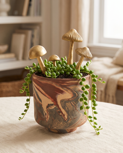 Tedros pot planted with gold mushroom stakes, styled in use
