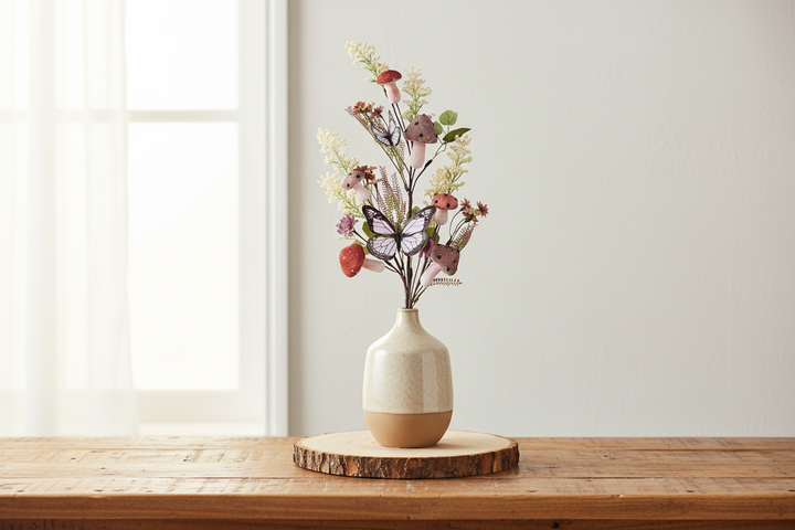 Decorative vase with flowers and butterflies on a wooden surface